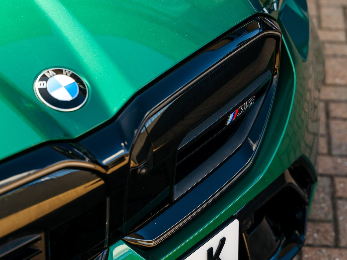 Close-up of glossy ceramic-coated paint on a green BMW